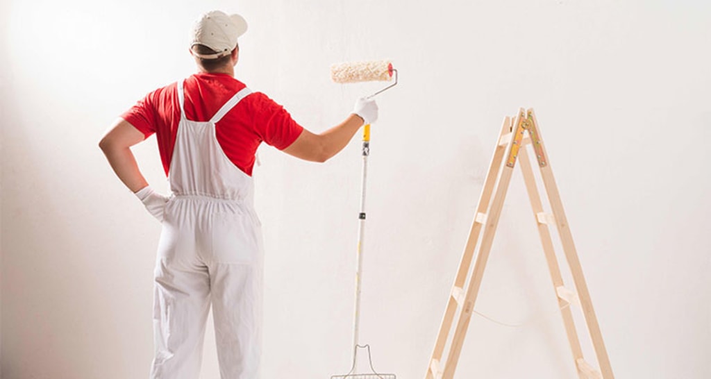 Painter applying finish to interior wall with roller